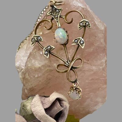 Close up photo of the pendant shown still displayed on the rose quartz.