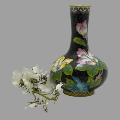 Main photo of the vase shown slightly off centre to the right with pink magnolias to right and yellow on left. There is also a peony flower bud on the neck of the vase.