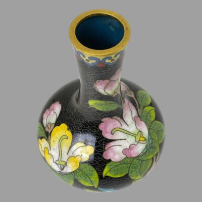 Photo of vase seen a little more in close up and from a raised angle looking diagonally down. The magnolia flowers are visible as is the air force blue coloured interior.