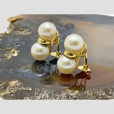 Photo of the earrings on top of a slice of agate and shown from a side angle with the earring fronts facing towards the left.