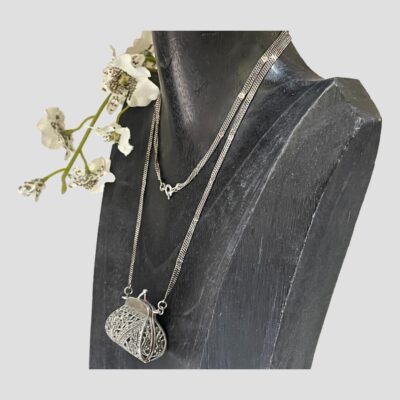 Photo of necklace on a dark wood display stand and seen from a slight side angle with the front of display facing towards the left.