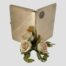 Main photo of case shown open and displayed upright. Both external sides of the case are on display with the MGM logo disc on the right side but centre top in this photo. There is a small posy of pale pink roses in the centre foreground - gives a real Hollywood look!