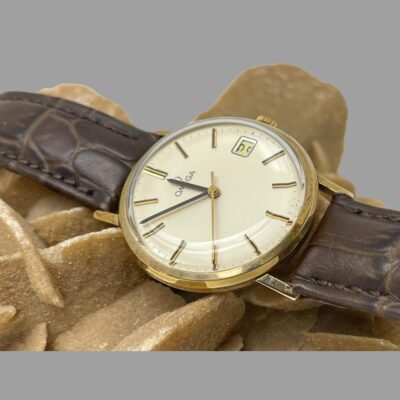Close up photo of the watch face displayed on top of desert sand rose.