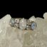 Main photo of ring displayed on top of some quartz crystal and seen with ring front forward facing. Quite a neutral colour palette on the opals at this angle and light but you can see the colours are there within.