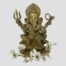 Main photo of Lord Ganesha seen from an eye level from the front. He is seen with all eight of his sacred symbol attributes on display namely, The goad, noose, rat, cobra belt, broken tusk, lotus base and tusk turned to his left (our right) There is a small spray of white orchid flowers across the floor at his base