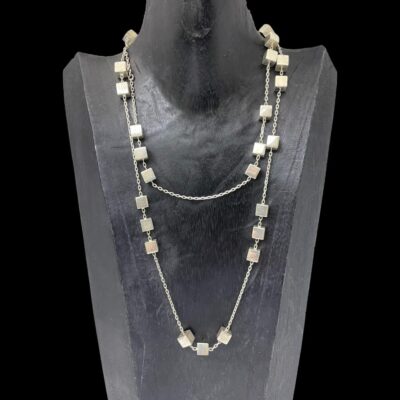 Photo of necklace displayed on a dark wood display stand and forward facing. It has been doubled up as the chain is very long.