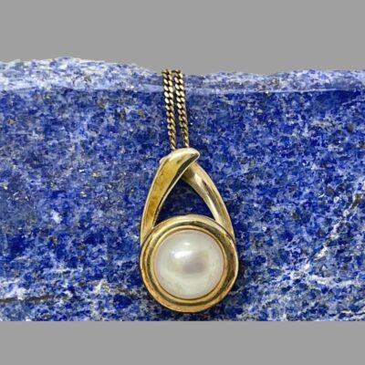 Close up photo of the pendant set against the lapis backdrop.