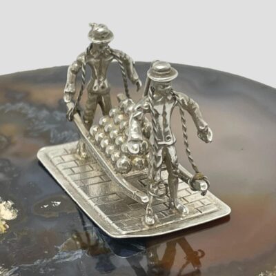 Close up view of the sailors seen facing towards the bottom right of the photo. They are still posed on top of natural agate.