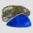 Main photo of brooch leaning up against a natural rock which houses the lapis but not showing the lapis side (although some blue coming thru the rock) The brooch is shown with the longest edge on the surface and the shortest edge to the right. This blue enamel is slightly darker like royal blue. There are multiple triangles sections within the triangle form each defined with horizontal lines which make them stand out.
