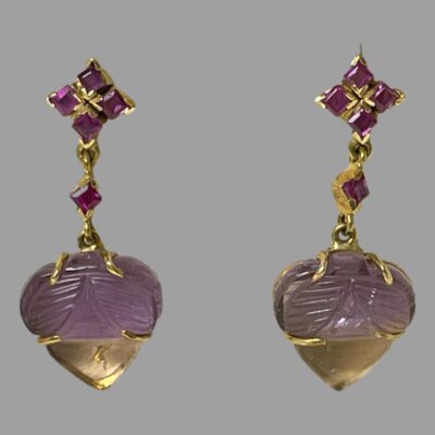 Photo of earrings shown hanging against a grey background.