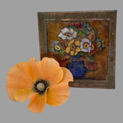 Main photo of picture displayed upright and forward facing. The anemones are in multiple colours and in a royal blue colour bulbous vase. The frame is square and in hammered copper. There is a pale orange coloured poppy flower to the left of the picture.