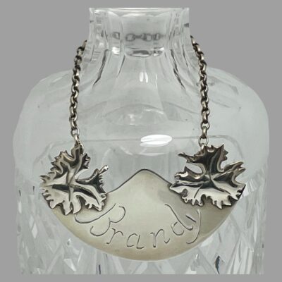 Main photo of ticket displayed hanging around the neck of a decanter and shown in close up forward facing.