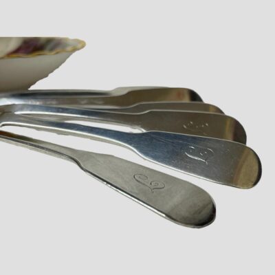 Close up photo of the ends of the spoon handles showing the letter T in old italic font.