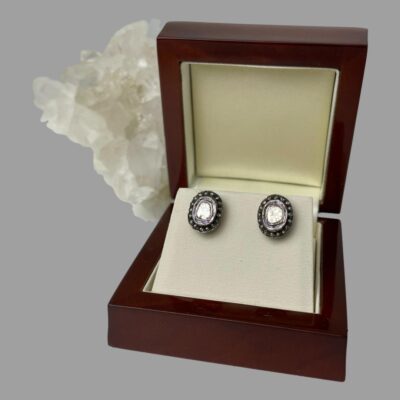 Main photo showing the earrings displayed inside their box. The box is at a slight angle to the left for both earrings to catch the light and shine! The box is of reddish brown wood and there is a rock of natural quartz crystal behind the open lid.