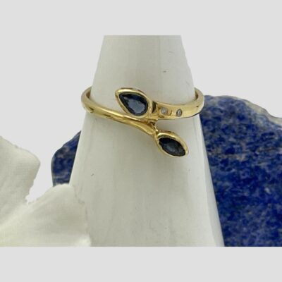 Close up of the ring front displayed on a cone shaped stand with the lapis rock behind.
