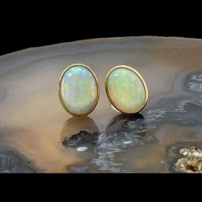 Main photo of earrings displayed on top of a slice of natural agate with the earring fronts facing forward.