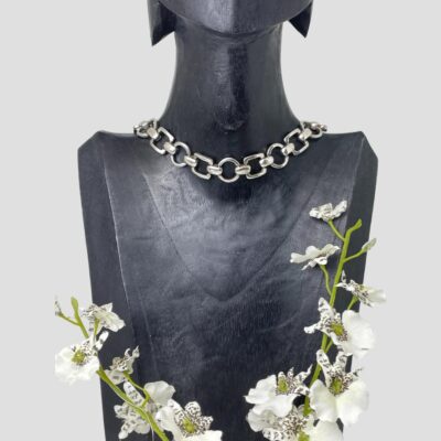 Main photo of collar necklace displayed on a dark wooden display stand which is forward facing. The links of this collar are square and circular alternately with nice solid silver links joining them all together. A really nice piece of solid silver jewellery in a modernistic style.