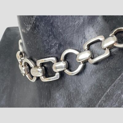 Close up photo of the collar seen from a slight side angle and still on the dark wooden display.