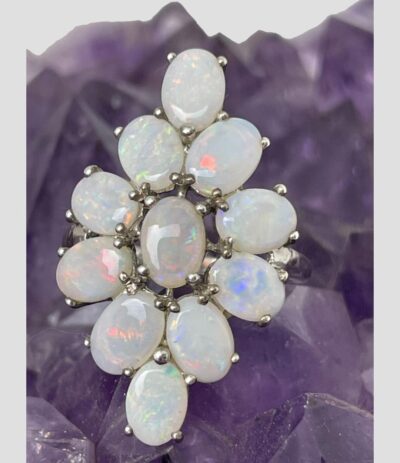 Close up photo of ring ring with some flashes of colour in each stone ranging from pink, orange, blue, green, etc