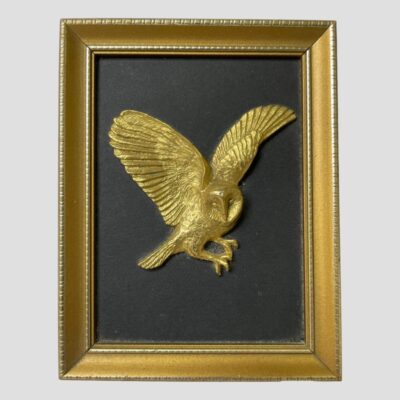 Photo of the owl picture only. Shown in flight and head facing the camera whilst wings are angled to fly right.
