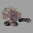 Main photo of the 2 cufflinks laid in front of a small rock of natural amethyst with both ends of the Blue John on display. The Blue John has a range of purple colouring from dark purple to lilac even clear in places.