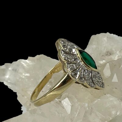 Secondary photo of the ring still on top of quartz crystal rock with the ring front facing towards the top right corner.