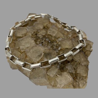 Secondary photo showing bracelet still displayed on top of natural quartz crystal with the chain links side in the foreground.