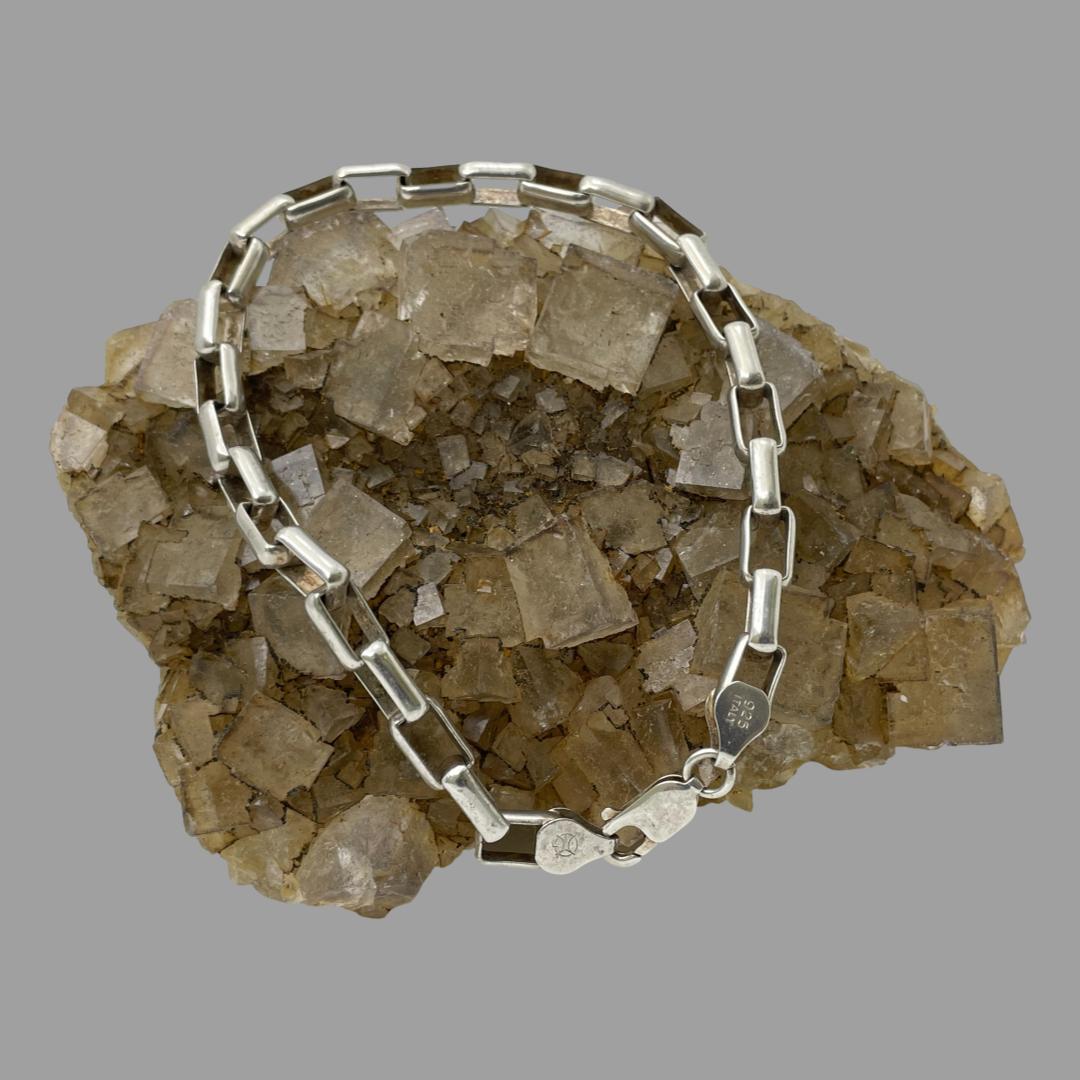 Main photo of bracelet shown displayed over a rock of natural quartz crystal which is a sand colour, The bracelet has the clasp closed which is displayed in the foreground