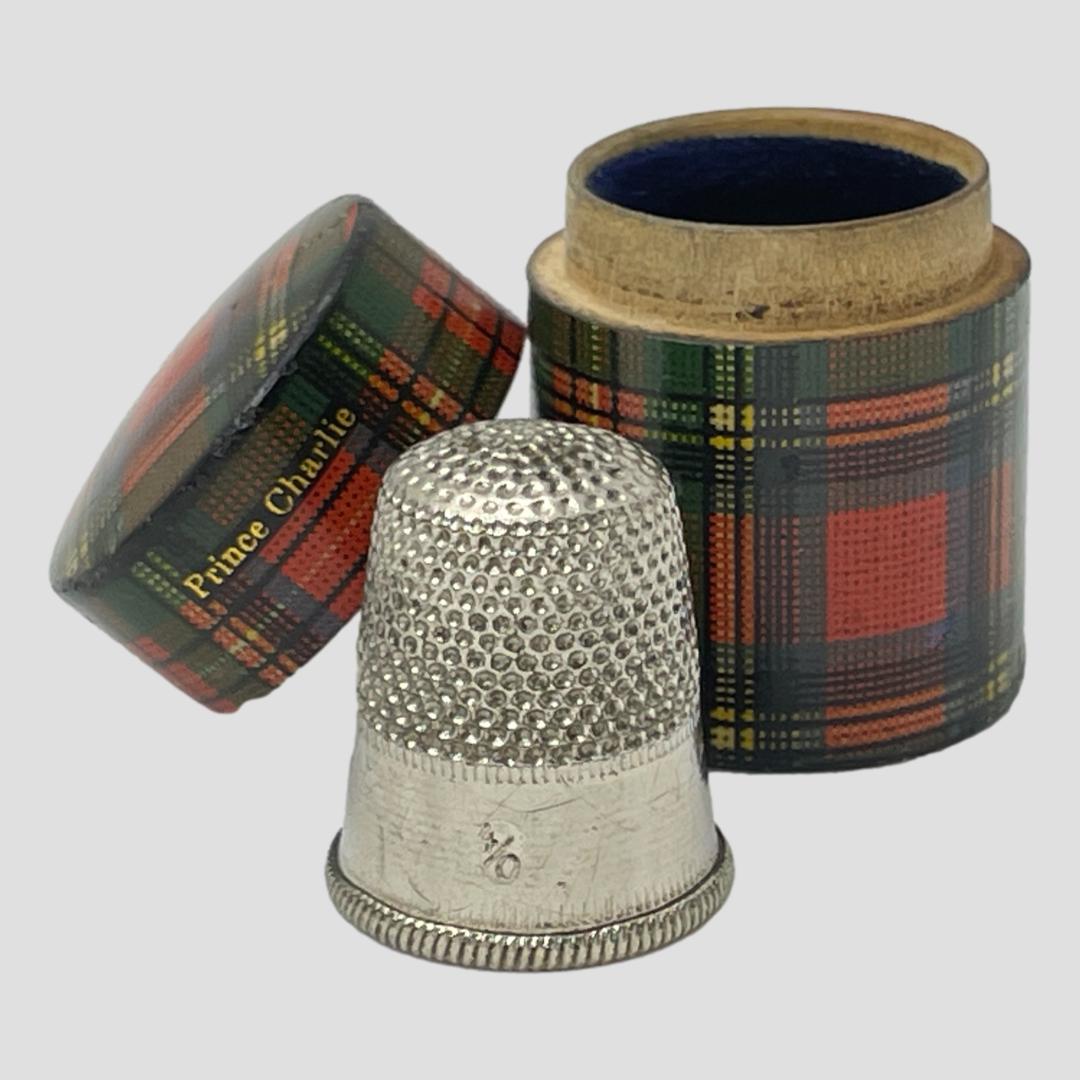 Main photo of the case seen with lid removed and leaning against the lower half of the case. The thimble is in the foreground with the 4/0 visible.