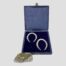 Main photo of the horseshoes displayed inside their fitted case and shown with the lid upright. The box is blue with a blue silk lining on inside lid and blue velvet where horseshoes sit. This would really make a perfect wedding present. (A small rock is to the left of the bottom of case which is holding the case at a slight upright angle.